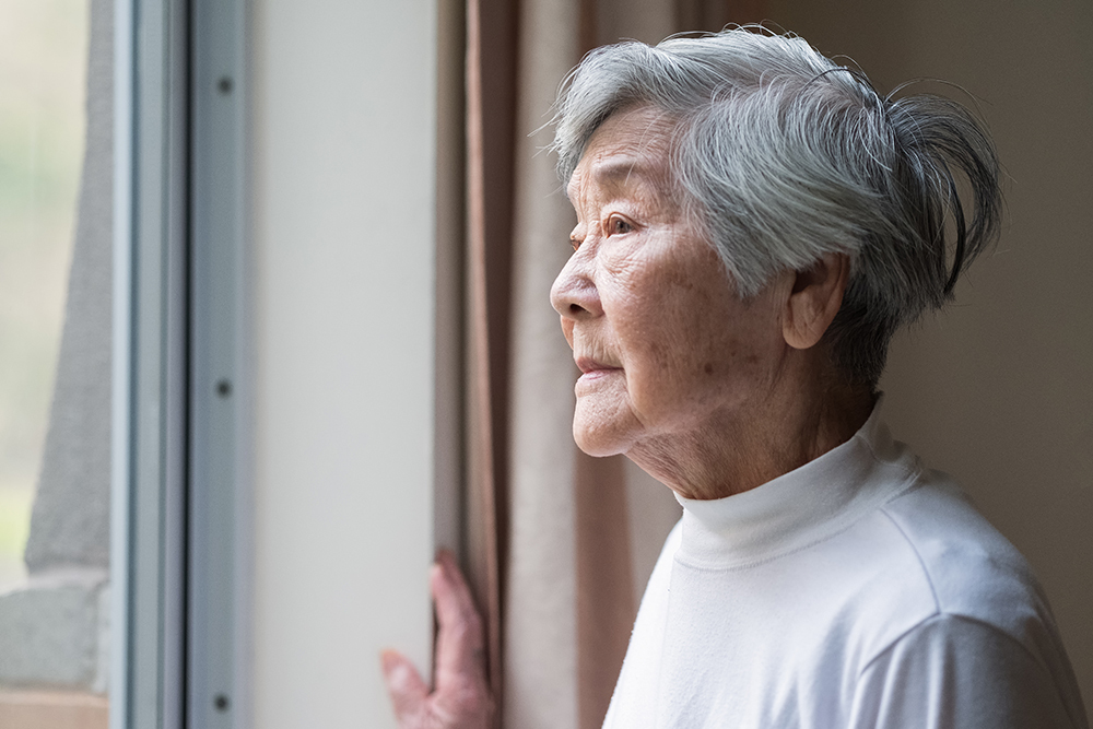 Woman over 65 years looking out of the window