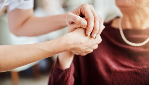 Getty Images-carer-and-older-patient-holding-hands-in-caring-way